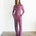 Woman wearing a purple jumpsuit standing against a white background